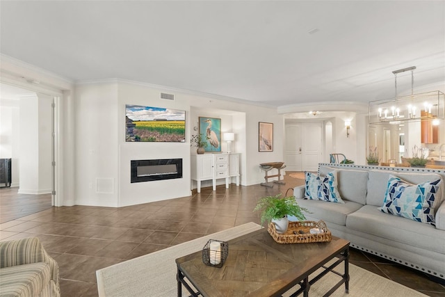 tiled living room featuring a notable chandelier and ornamental molding