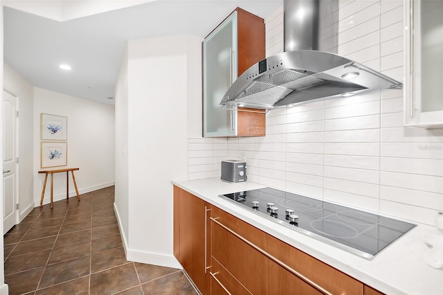 kitchen with backsplash, black electric cooktop, dark tile patterned floors, and wall chimney range hood