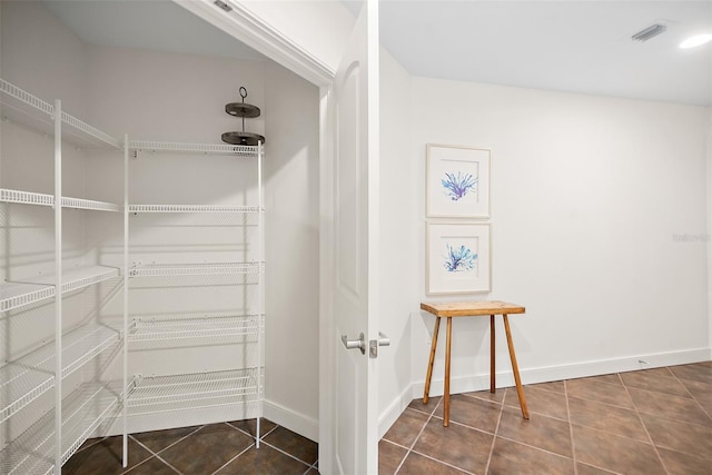 spacious closet with dark tile patterned flooring