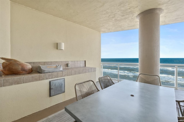 dining room with a beach view, a water view, and a wealth of natural light