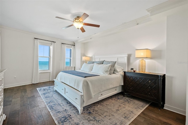 bedroom with dark hardwood / wood-style flooring, ceiling fan, and crown molding