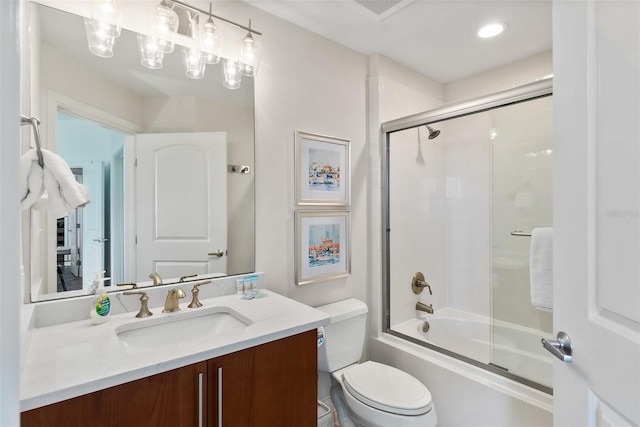 full bathroom with combined bath / shower with glass door, vanity, and toilet