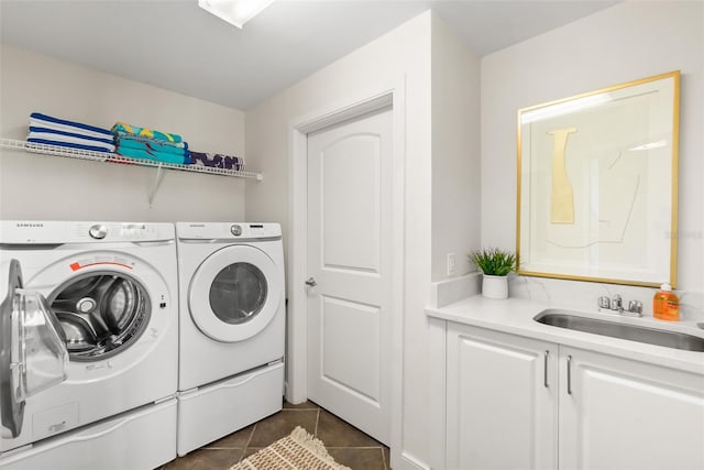 laundry area with cabinets, dark tile patterned flooring, washer and clothes dryer, and sink