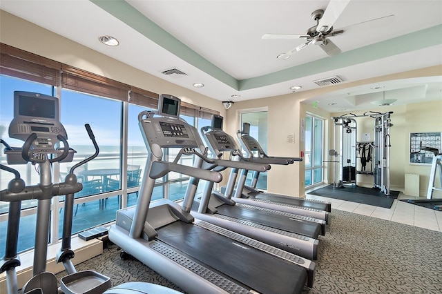 exercise room with light colored carpet and ceiling fan