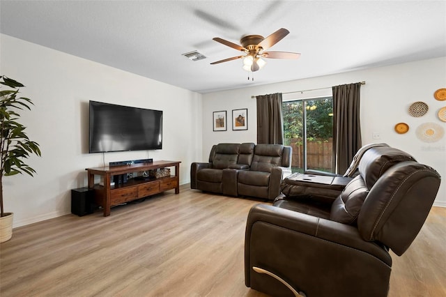 living room with a textured ceiling, light hardwood / wood-style floors, and ceiling fan