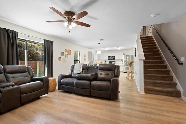 living room featuring ceiling fan and light hardwood / wood-style flooring