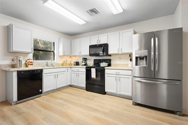 kitchen with black appliances, sink, a textured ceiling, light hardwood / wood-style floors, and white cabinetry