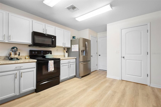 kitchen with black appliances, light hardwood / wood-style floors, and white cabinetry