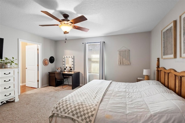 carpeted bedroom featuring ceiling fan and a textured ceiling