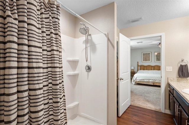 bathroom with vanity, a textured ceiling, hardwood / wood-style flooring, and curtained shower