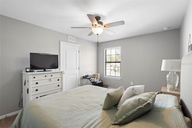 carpeted bedroom featuring a textured ceiling and ceiling fan