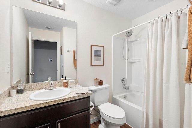 full bathroom featuring a textured ceiling, vanity, toilet, and shower / bath combo with shower curtain