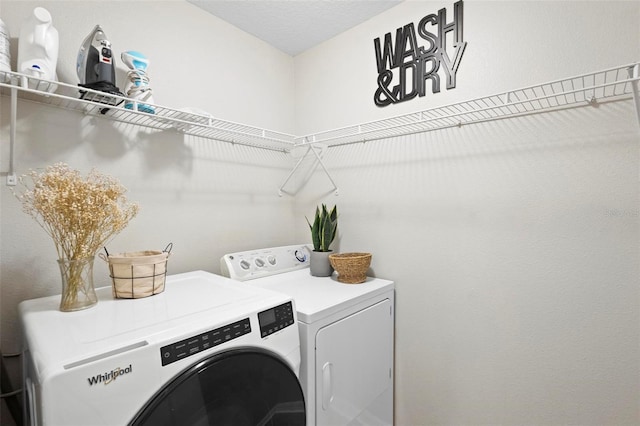 laundry room with a textured ceiling and separate washer and dryer