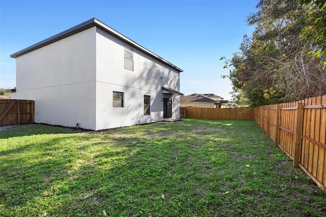 rear view of property featuring a lawn