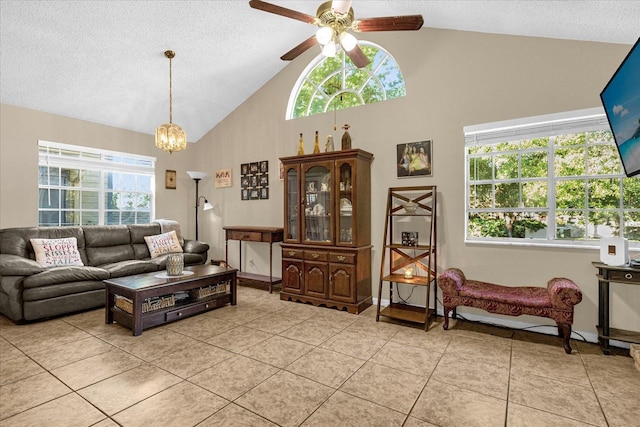 living room featuring plenty of natural light, light tile patterned flooring, and ceiling fan with notable chandelier