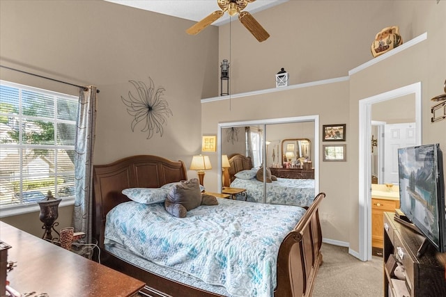 carpeted bedroom with ensuite bathroom and ceiling fan