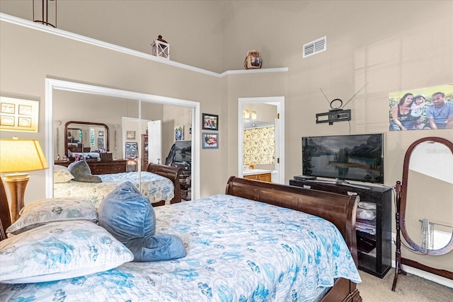 bedroom with carpet, a high ceiling, and ensuite bath