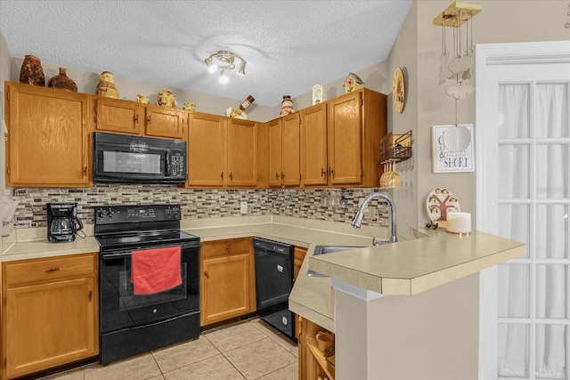 kitchen with black appliances, decorative backsplash, light tile patterned floors, a textured ceiling, and kitchen peninsula