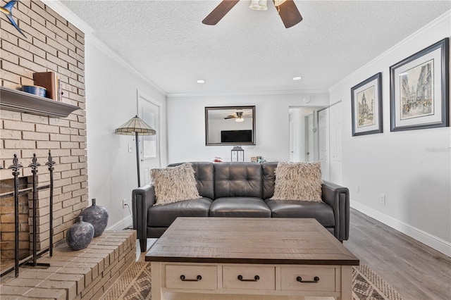 living room featuring a textured ceiling, light wood-type flooring, and ornamental molding