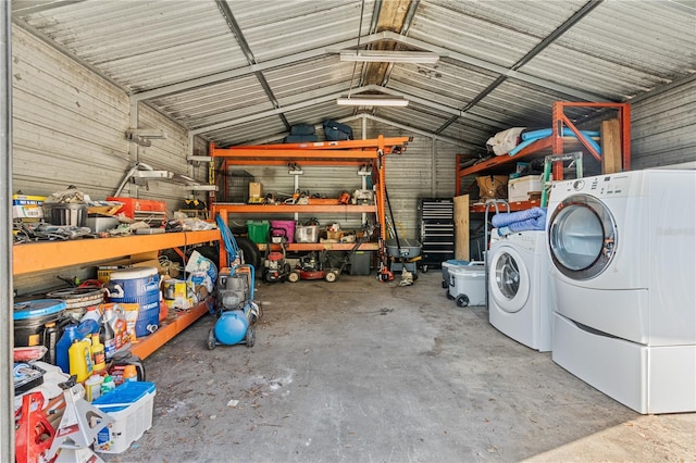 garage featuring a workshop area, wooden walls, and washing machine and dryer