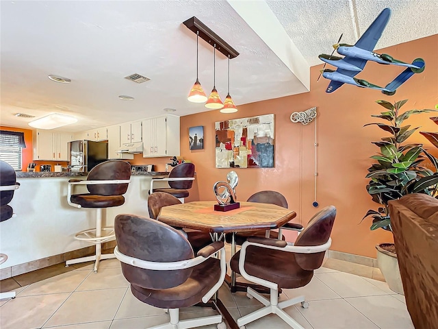 dining room featuring light tile patterned flooring and a textured ceiling