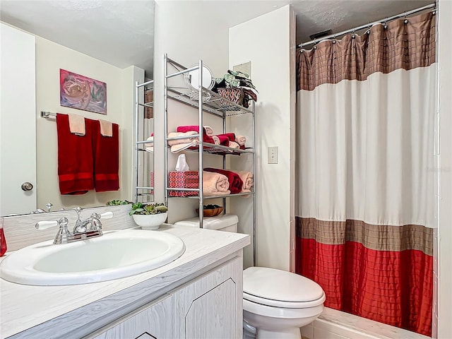 bathroom with vanity, curtained shower, and toilet