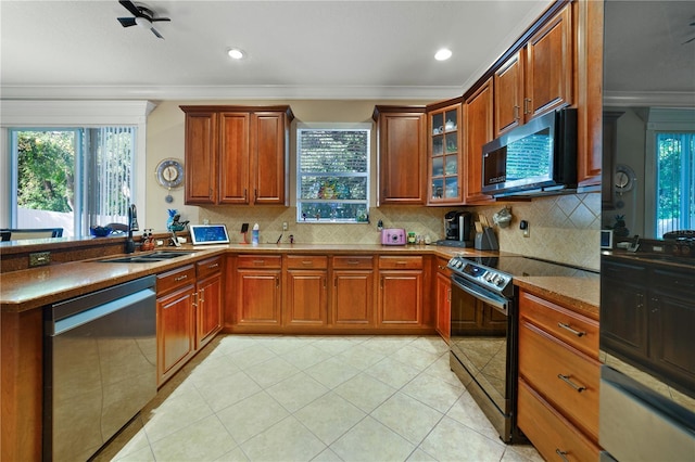 kitchen with sink, crown molding, decorative backsplash, ceiling fan, and stainless steel appliances