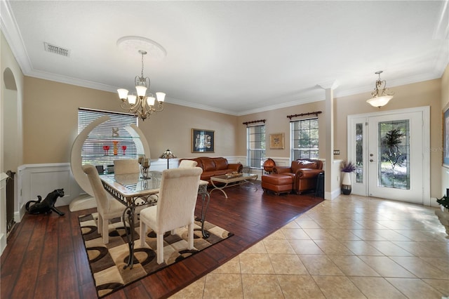 tiled dining room with crown molding and a notable chandelier