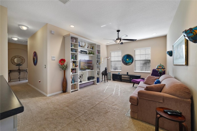 carpeted living room featuring ceiling fan and a textured ceiling