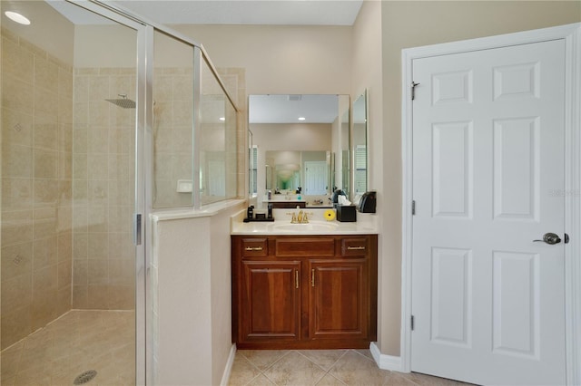 bathroom featuring tile patterned flooring, vanity, and a shower with shower door