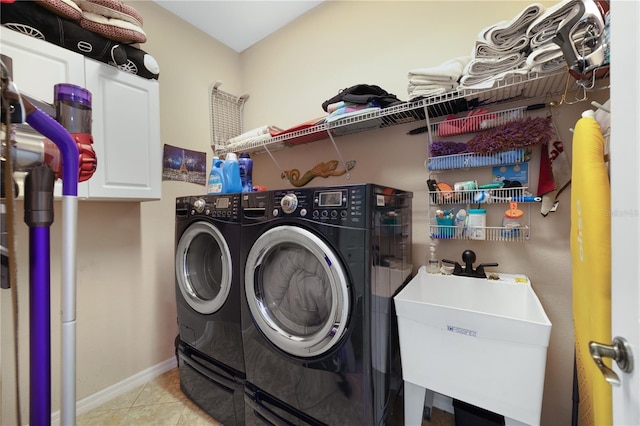 washroom with cabinets, washing machine and dryer, light tile patterned flooring, and sink