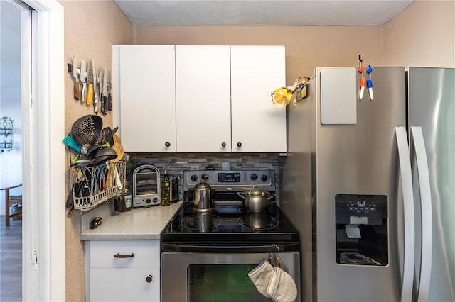 kitchen featuring backsplash, white cabinetry, and appliances with stainless steel finishes