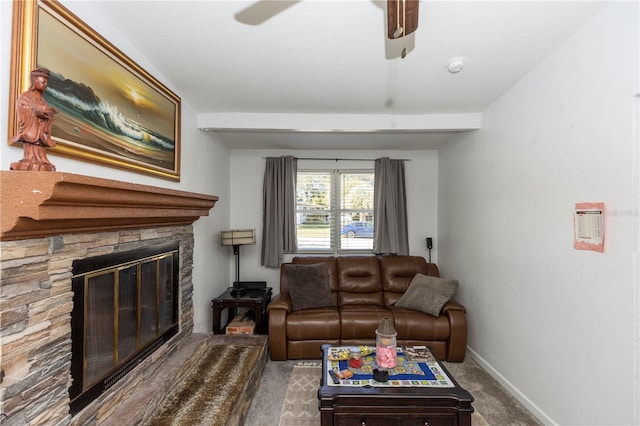 living room with carpet floors, ceiling fan, and a stone fireplace