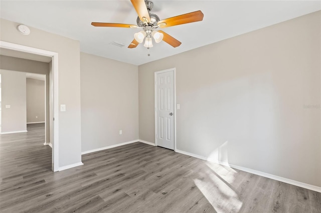 spare room featuring ceiling fan and dark hardwood / wood-style flooring