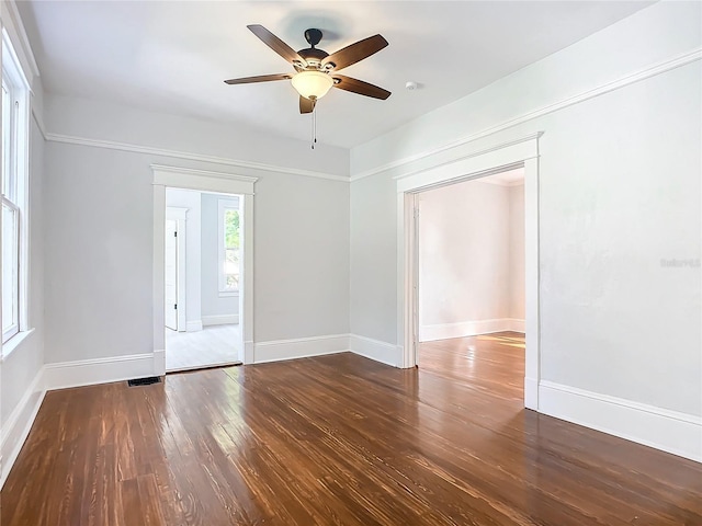 empty room with ceiling fan and dark wood-type flooring