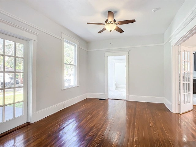 empty room with ceiling fan and dark hardwood / wood-style flooring