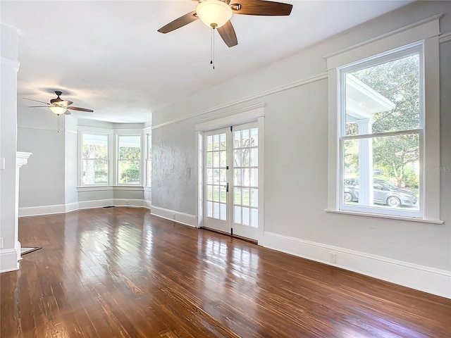 unfurnished living room with french doors, dark hardwood / wood-style floors, and ceiling fan