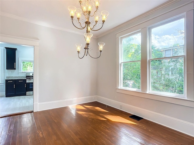 empty room with ornamental molding, dark wood-type flooring, and a chandelier