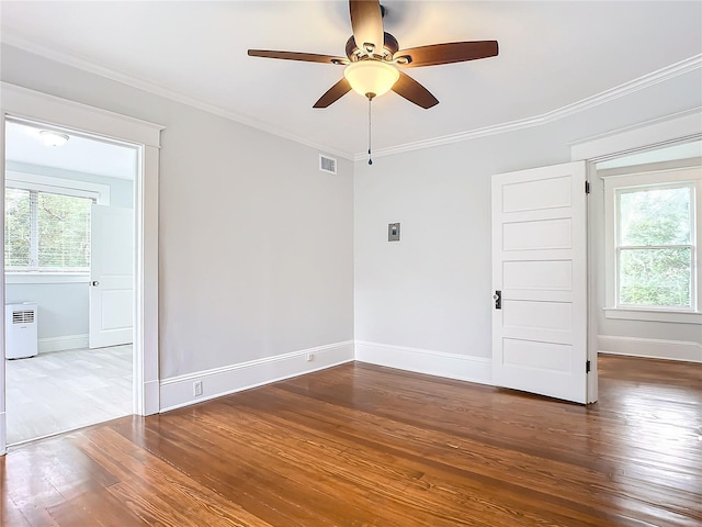 unfurnished room with a wealth of natural light, ceiling fan, wood-type flooring, and ornamental molding