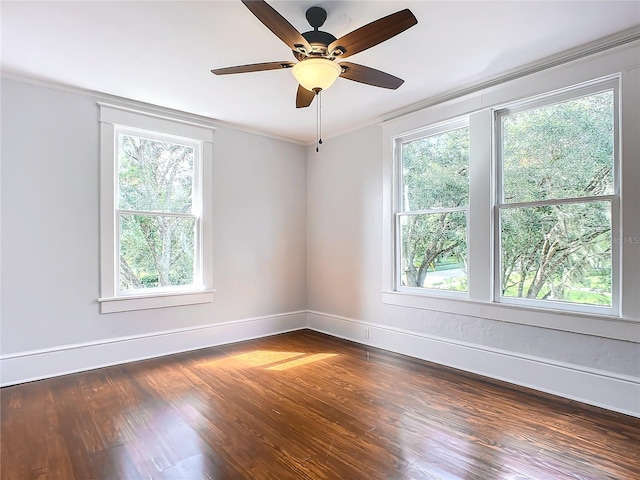 empty room with dark hardwood / wood-style floors, crown molding, ceiling fan, and a healthy amount of sunlight