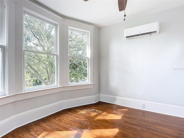 empty room with a wall unit AC and wood-type flooring