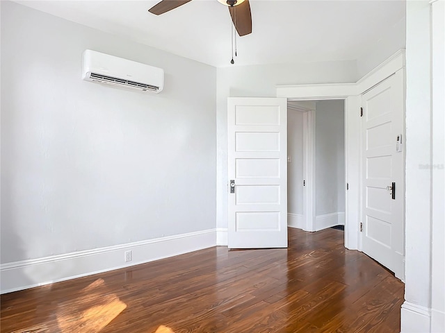 spare room featuring an AC wall unit, ceiling fan, and dark wood-type flooring