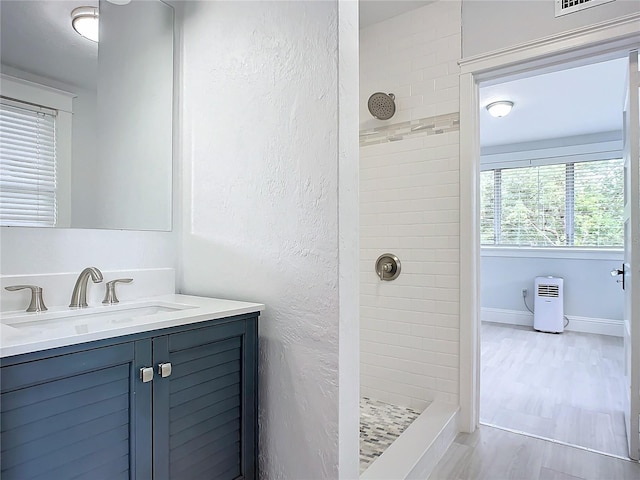 bathroom with vanity and tiled shower