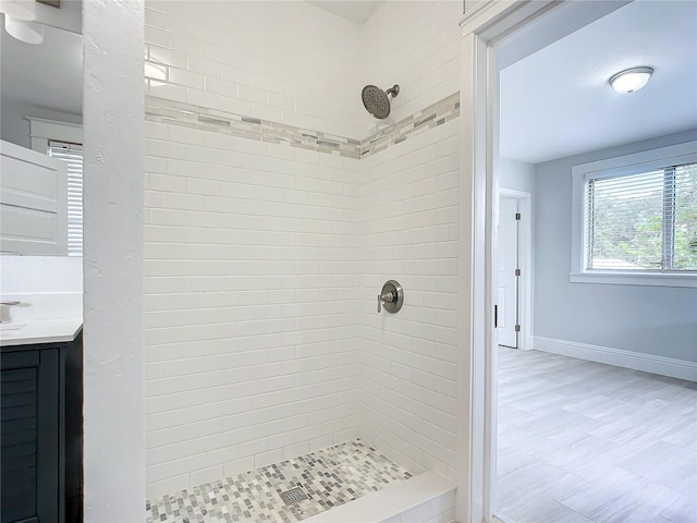 bathroom with vanity and tiled shower