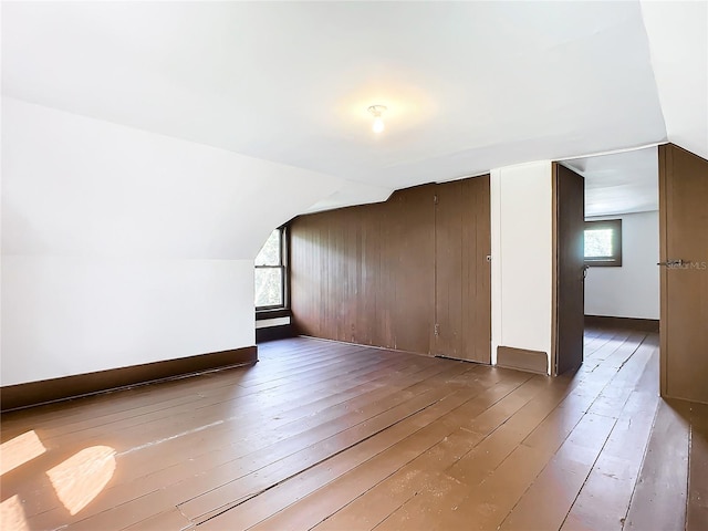 bonus room with plenty of natural light, hardwood / wood-style floors, and vaulted ceiling