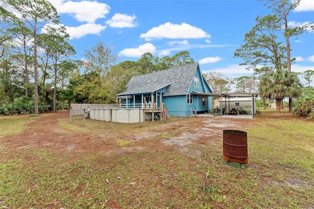 back of house featuring a yard and a carport