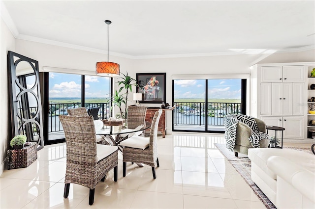 tiled dining space featuring a water view, a wealth of natural light, and crown molding