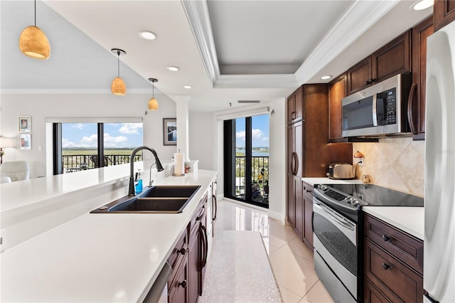 kitchen with hanging light fixtures, a healthy amount of sunlight, sink, and stainless steel appliances