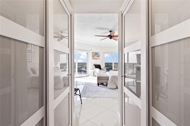 interior space featuring tile patterned flooring, ceiling fan, ornamental molding, and french doors