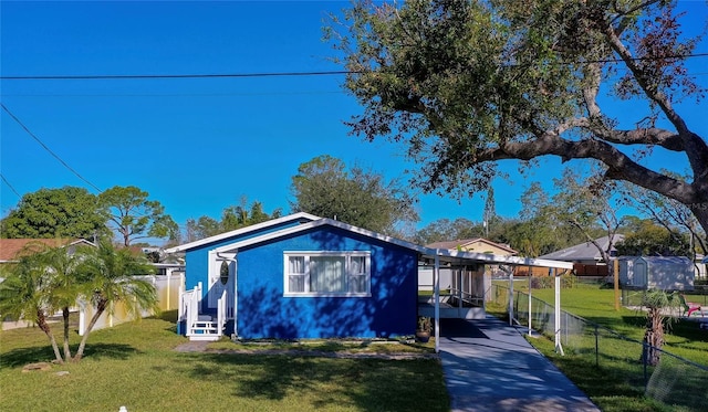 view of front of property featuring a front yard and a carport